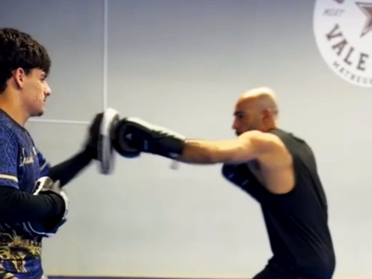 Aluno acertando um direto na manopla durante a aula de boxe