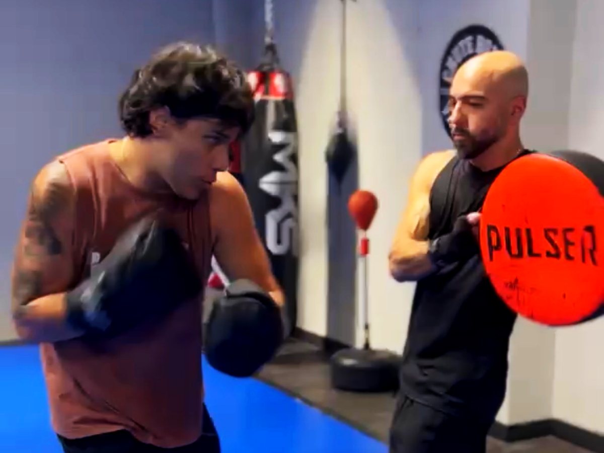 Aluno de luva em guarda e o parceiro segurando a manopla