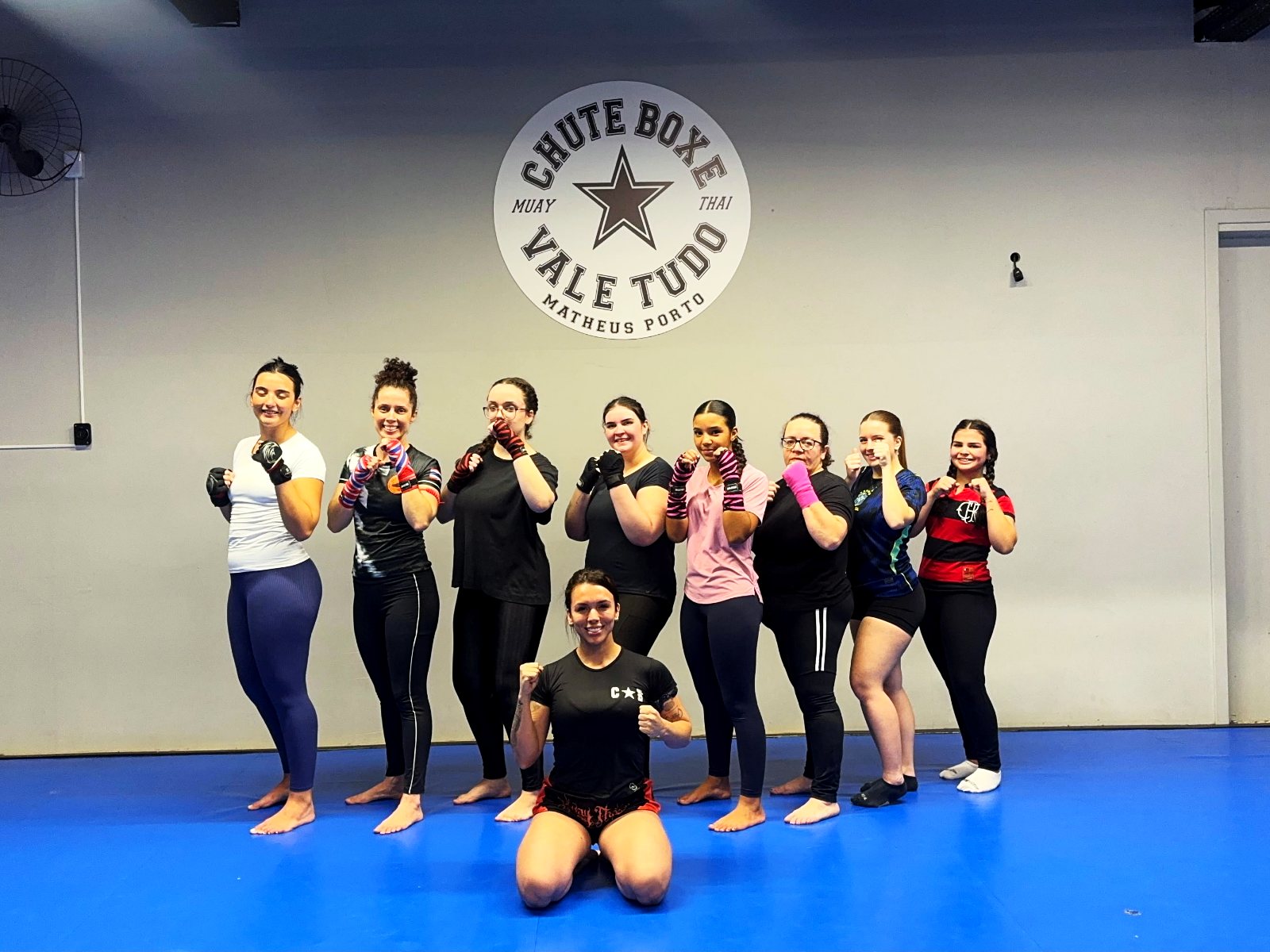 Turma feminina de muay thai do Distrito da Luta reunida no tatame
