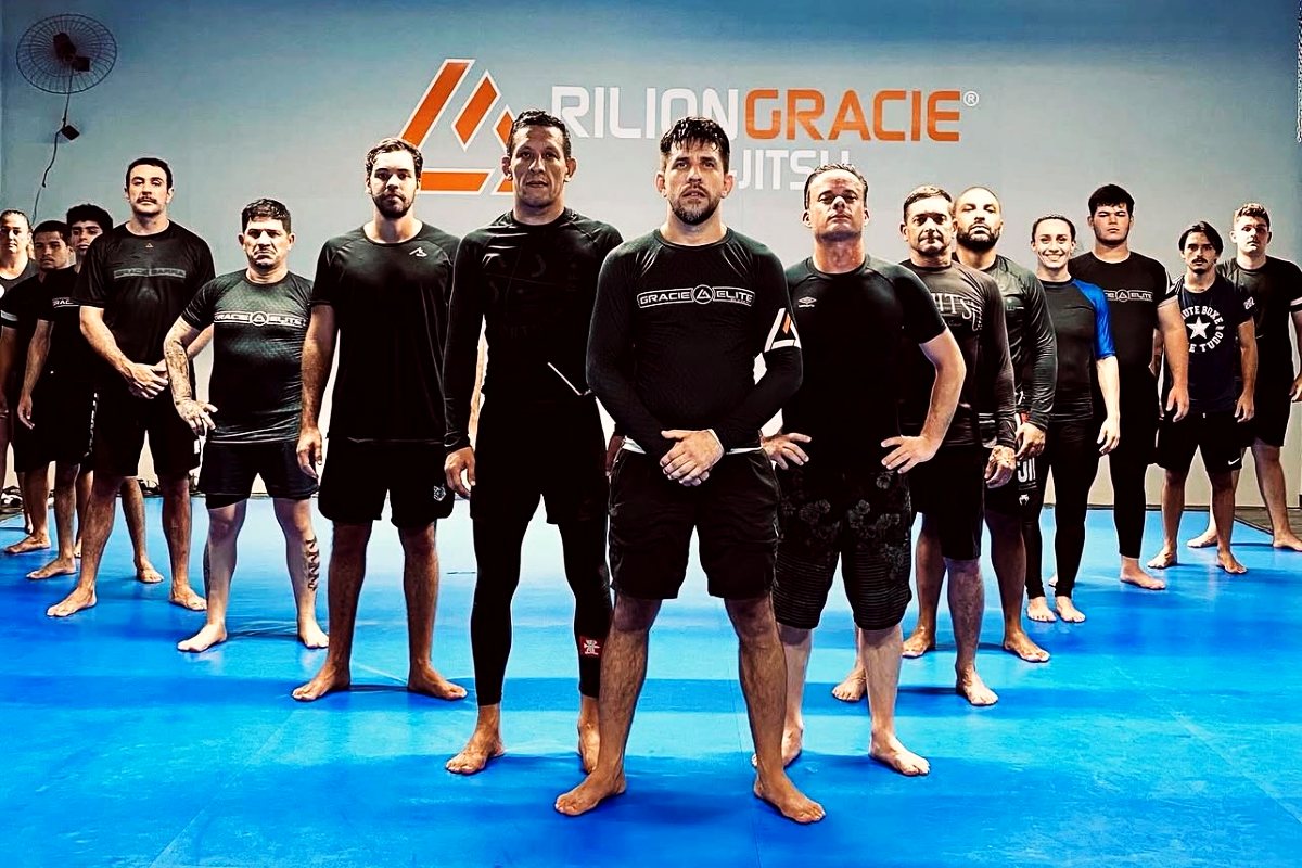 Turma de jiu-jitsu do Distrito da Luta em frente ao painel da Rilion Gracie